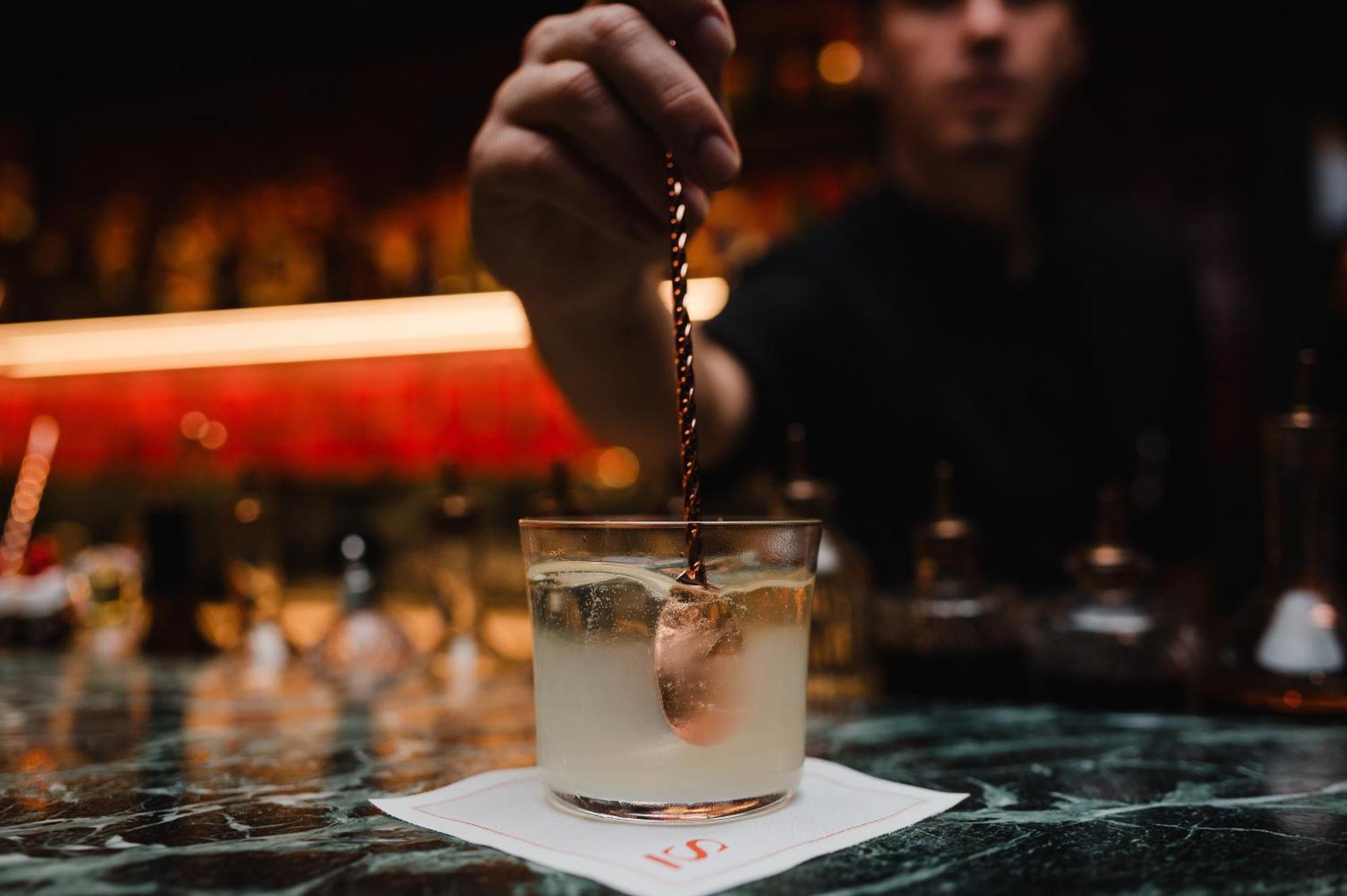 Sly Berlin Hotel Bagian luar foto A bartender adding a garnish to a cocktail